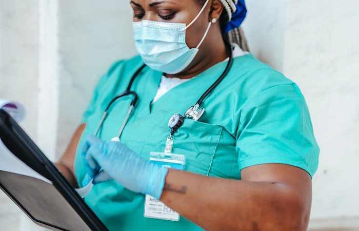 Crop nurse in mask and gloves with papers - nurse recruiter