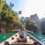 last minute vacation deals featured image woman on boat in beautiful scenery